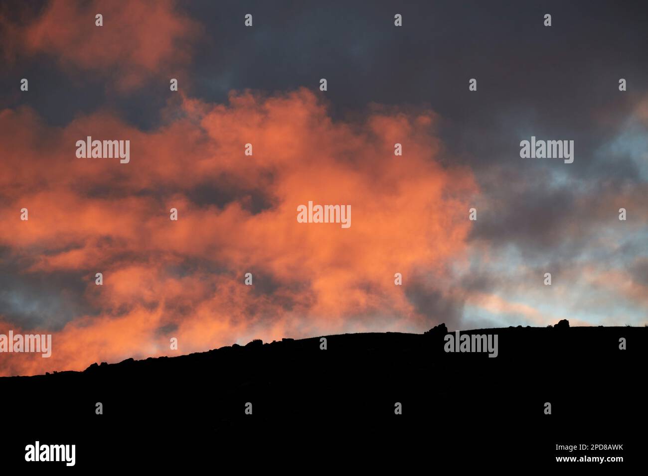 Cielo rosso di notte un cielo rosso nuvoloso tramonto sopra la silhouette di una cresta di montagna Lanzarote, Isole Canarie, Spagna Foto Stock
