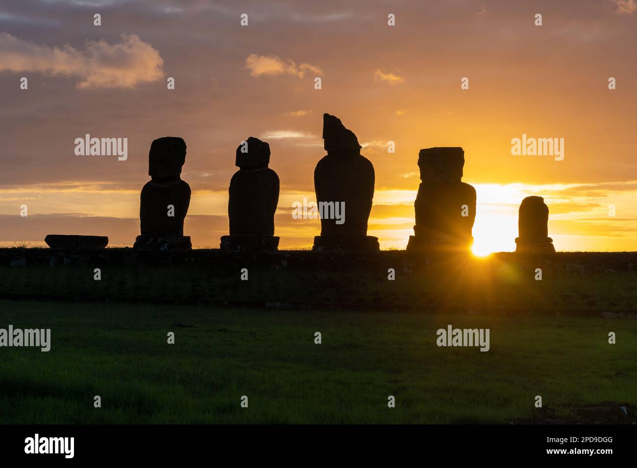 Tramonto dietro le statue di moai su AHU Vai Ure nel complesso di Tahai sull'isola di Pasqua (Rapa Nui) in Cile. Foto Stock