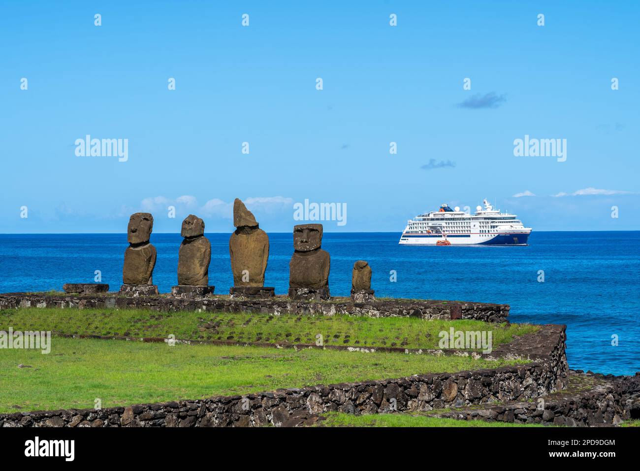 Isola di Pasqua, Cile - 5 marzo 2023: Statue di moai su AHU Vai Ure con una nave da crociera sullo sfondo del complesso di Tahai sull'isola di Pasqua, Cile. Foto Stock