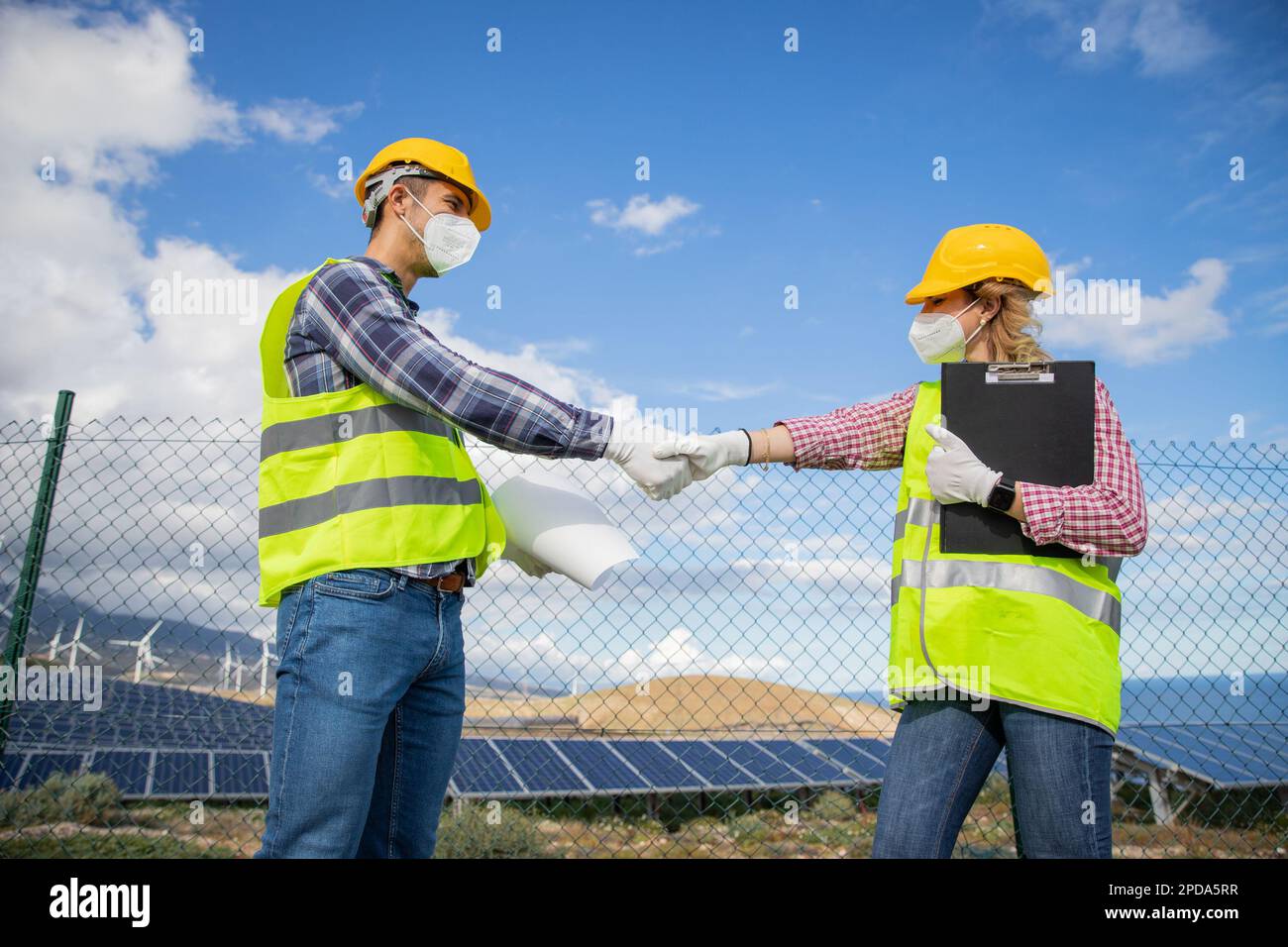 Due colleghi che scuotono le mani al lavoro in una centrale di energia solare, il concetto di accordo e accordo fatto trovato Foto Stock Due colleghi che scuotono le mani al lavoro in una centrale di energia solare, il concetto di accordo e accordo fatto trovato Foto Stock