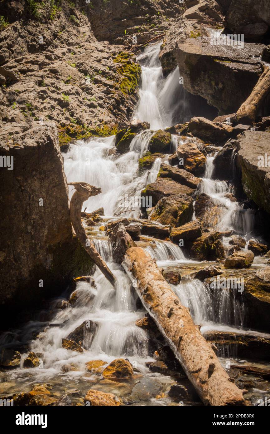 Una breve cascata che scende lungo le rocce in montagna Foto Stock
