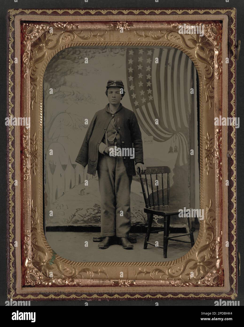 Soldato non identificato in uniforme con braccio in fionda davanti allo sfondo dipinto che mostra il campo militare e la bandiera americana. Liljenquist Famiglia Collezione di fotografie della Guerra civile , pp/liljunion. Soldati, 1860-1870, uniformi militari, 1860-1870, ferite e ferite, 1860-1870, backdrops, 1860-1870, Stati Uniti, Storia, Guerra civile, 1861-1865, personale militare, Unione. Foto Stock