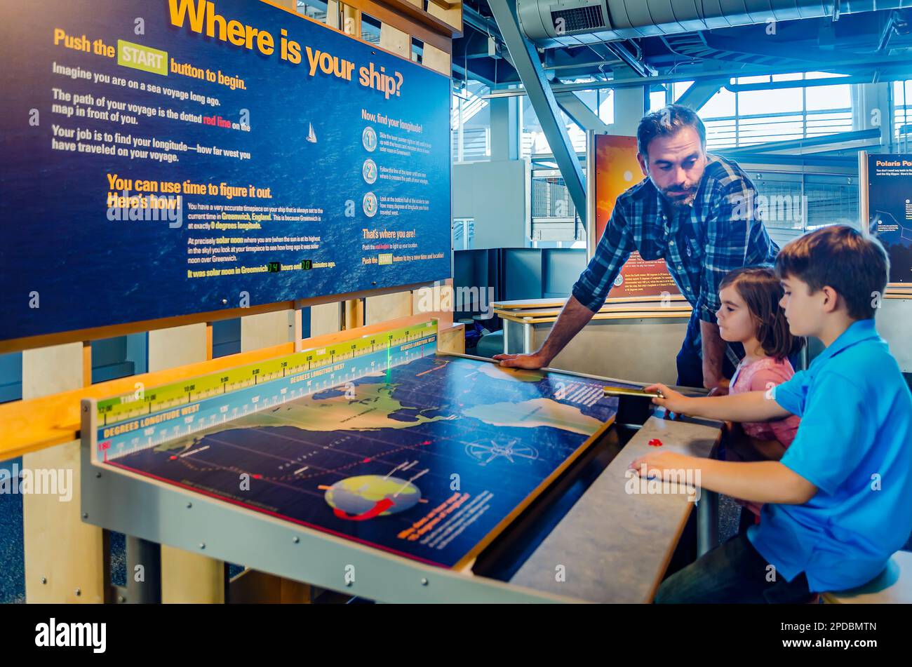 Un padre aiuta la sua i bambini mentre esplorano una mostra interattiva a GulfQuest Museo Nazionale Marittimo del Golfo del Messico, 27 novembre 2015, in Foto Stock