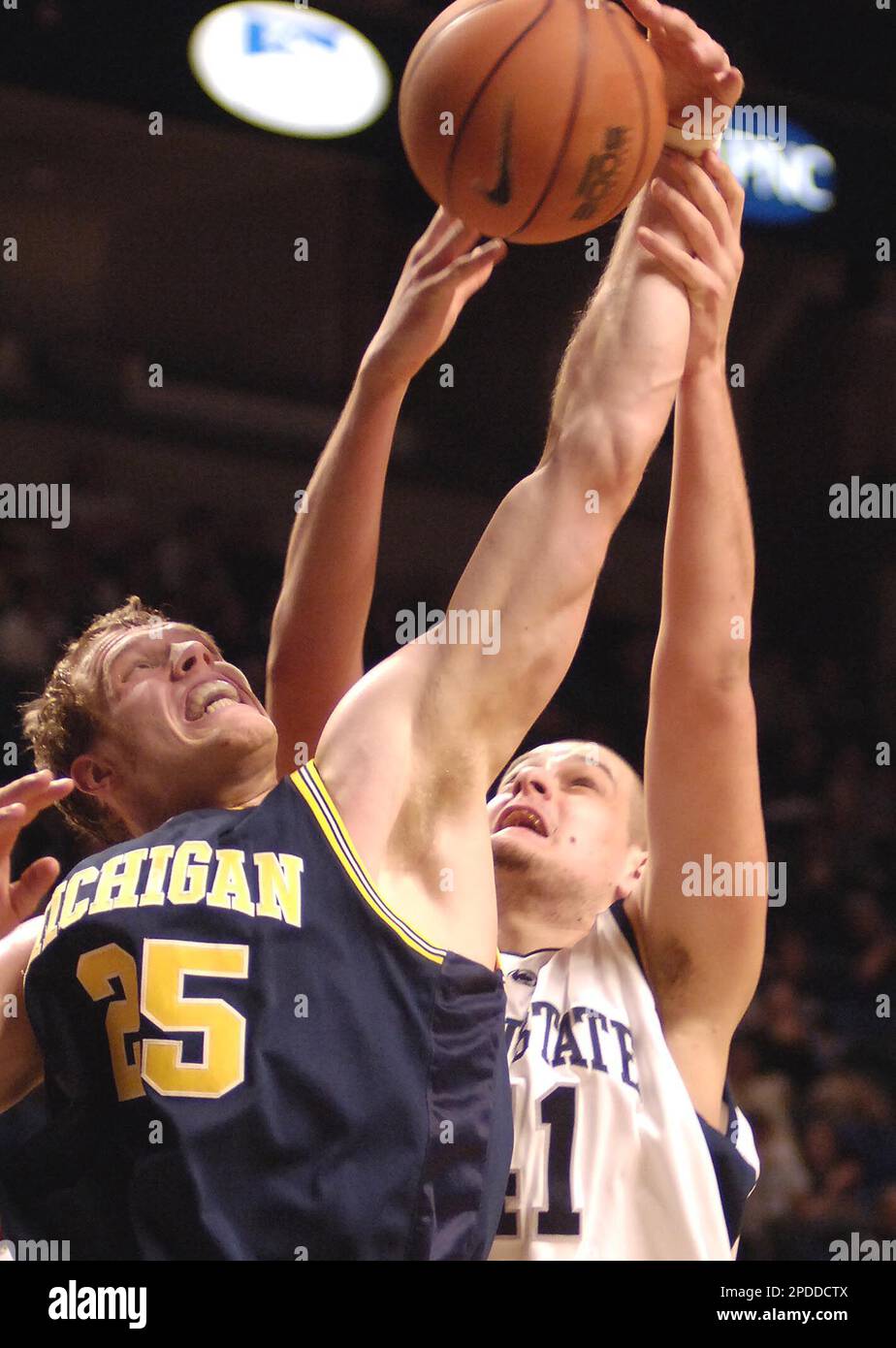 Michigan's Graham Brown (25) and Penn State's Milos Bogetic fight for a rebound during the first half of a college basketball game Wednesday, Feb. 1, 2006, in State College, Pa. (AP Photo/Pat Little) Foto Stock