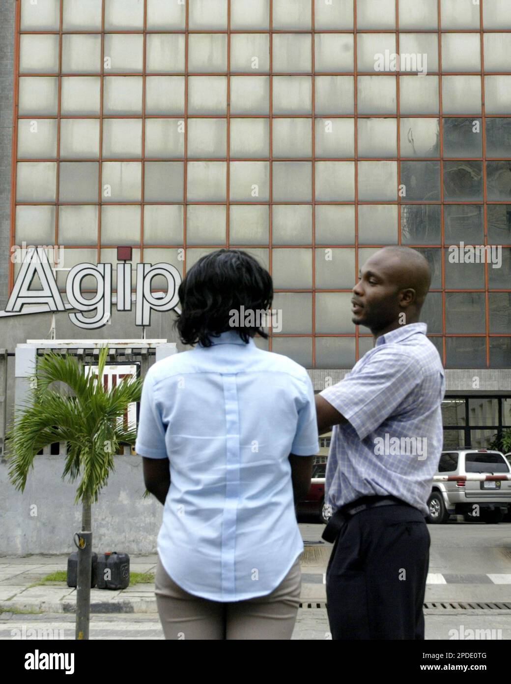 Two unidentified Agip oil workers stand outside the Nigeria Agip head office building in Lagos, Nigeria, Thursday, Jan 26, 2006. A recent spate of armed attacks which forced oil multinationals to evacuate hundreds of staff and slash output may only be a foretaste of growing unrest, with observers saying oil facilities remain vulnerable to increasingly powerful militias. In the latest incident Tuesday, camouflage-clad armed robbers stormed the offices of Italian oil company Agip in Port Harcourt, making their getaway in speedboats after killing nine people in the attack. (AP Photo/George Osodi) Foto Stock