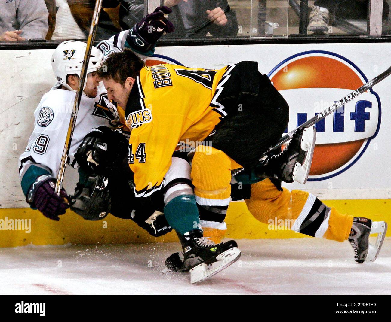 Boston Bruins' Nick Boynton (44) loses his helmet wile checking Mighty Ducks of Anaheim's Andy McDonald during the second period of the Bruins a 4-3 overtime win in NHL hockey in Boston Monday, Jan. 16, 2006. (AP Photo/Winslow Townson) Foto Stock