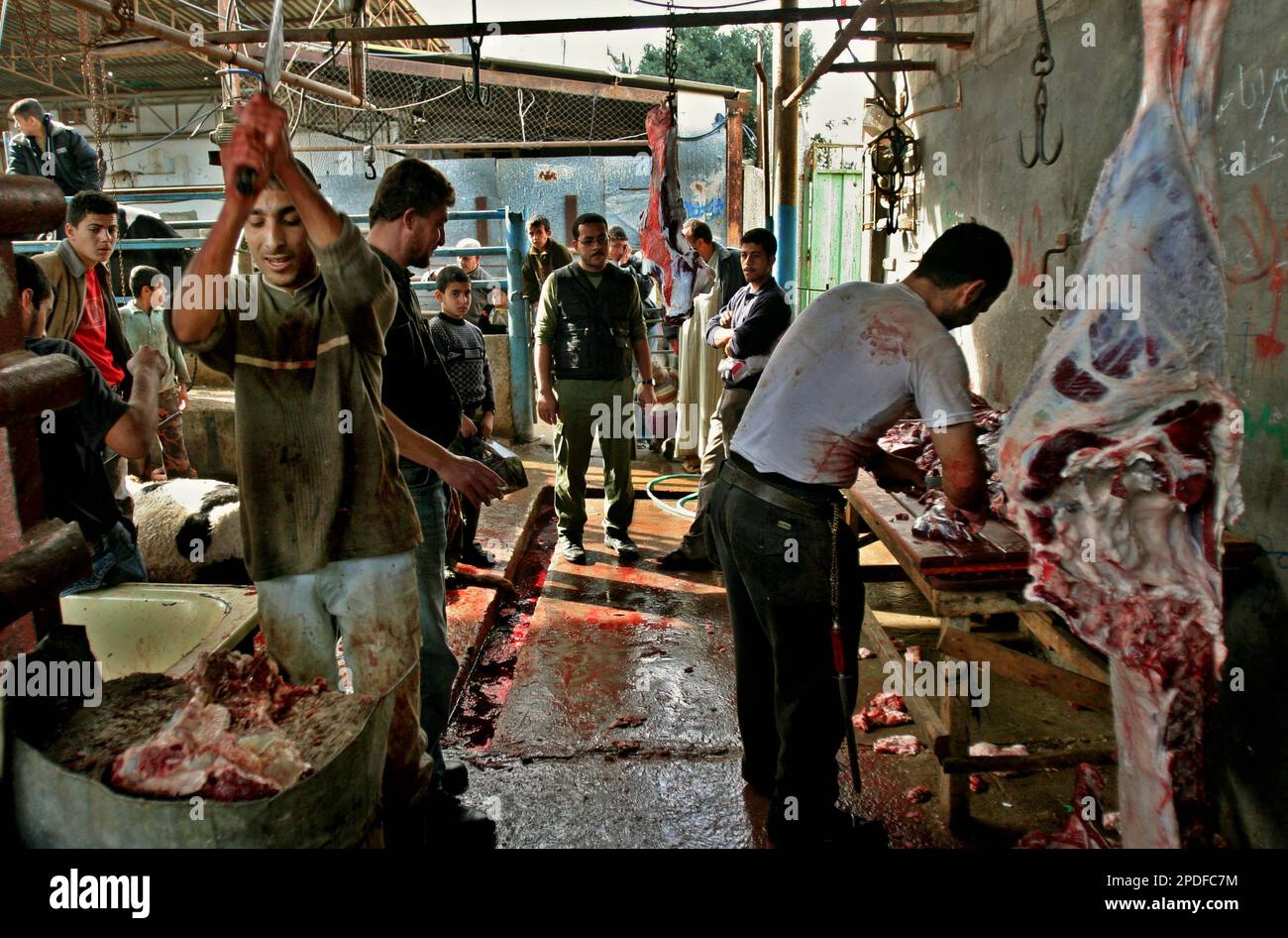 Palestinian butchers cut the meat of slaughtered cows on the first day of Eid AlAdha at a