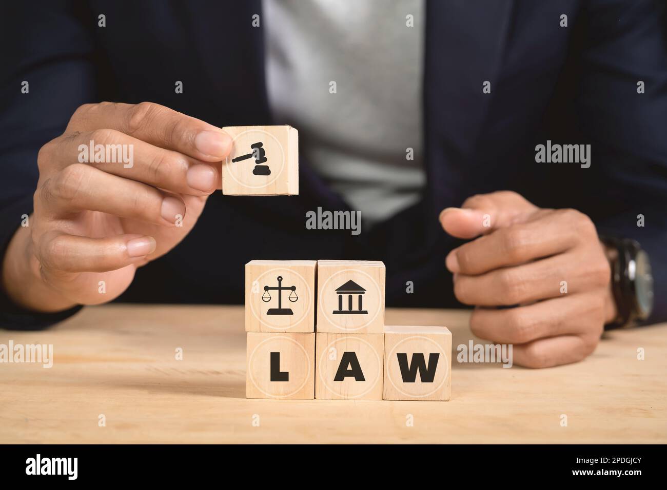 Uomo che tiene cubo di legno con icona legge. Diritto commerciale e giustizia banner, scala e equità. spazio di copia Foto Stock
