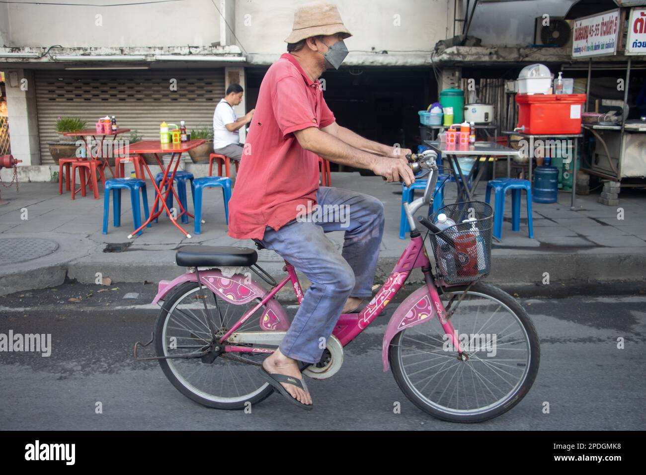 SAMUT PRAKAN, THAILANDIA, 28 2023 GENNAIO, Un uomo in bicicletta su strada città. Foto Stock