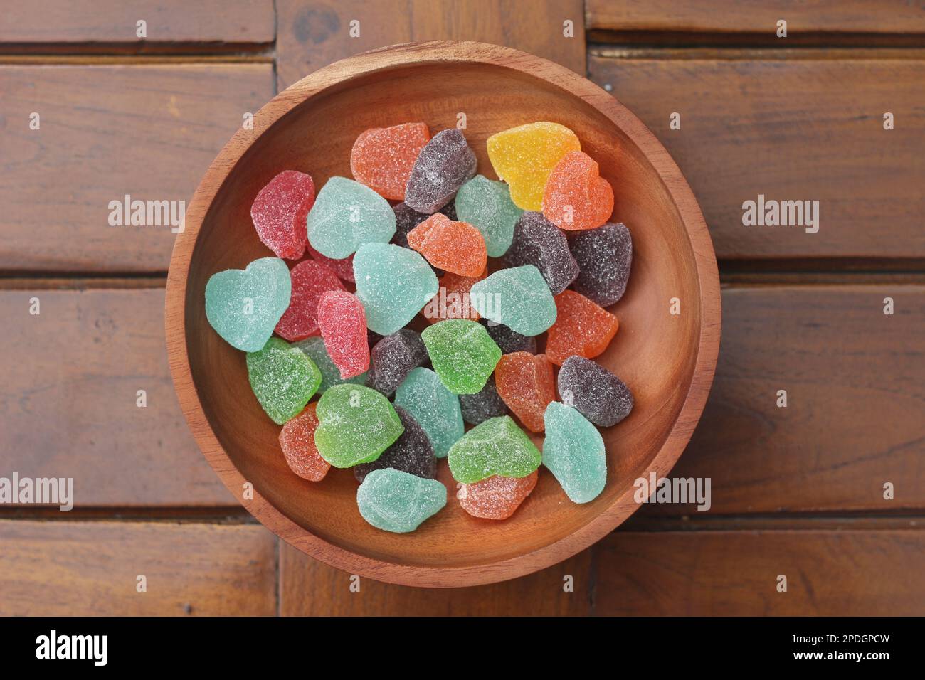 un primo piano di caramelle gommose di vari colori e sapori di frutta servite in una ciotola di legno. Foto Stock