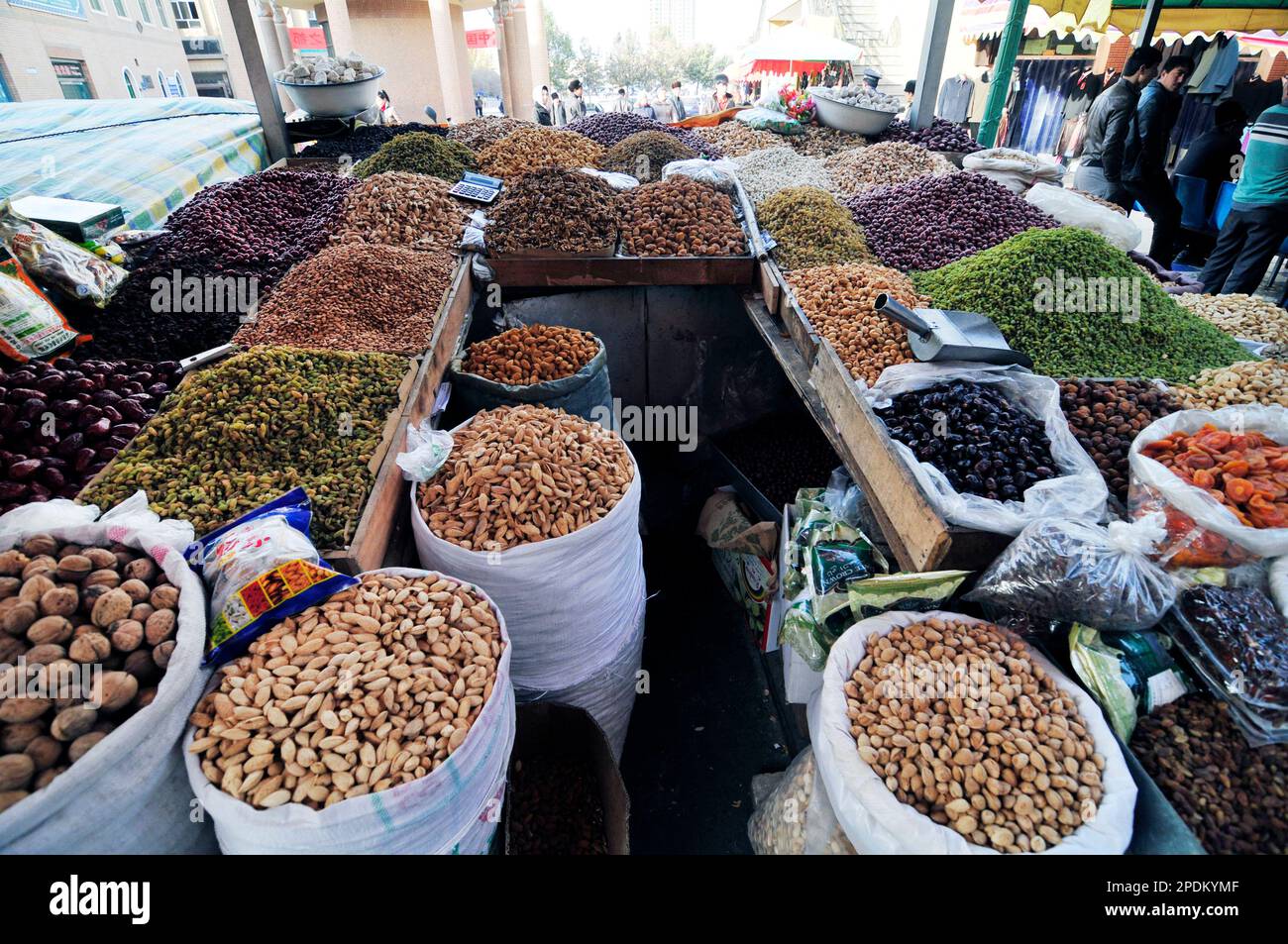 Un venditore di frutta secca e noci nella città vecchia di Kashgar, Xinjiang, Cina. Foto Stock