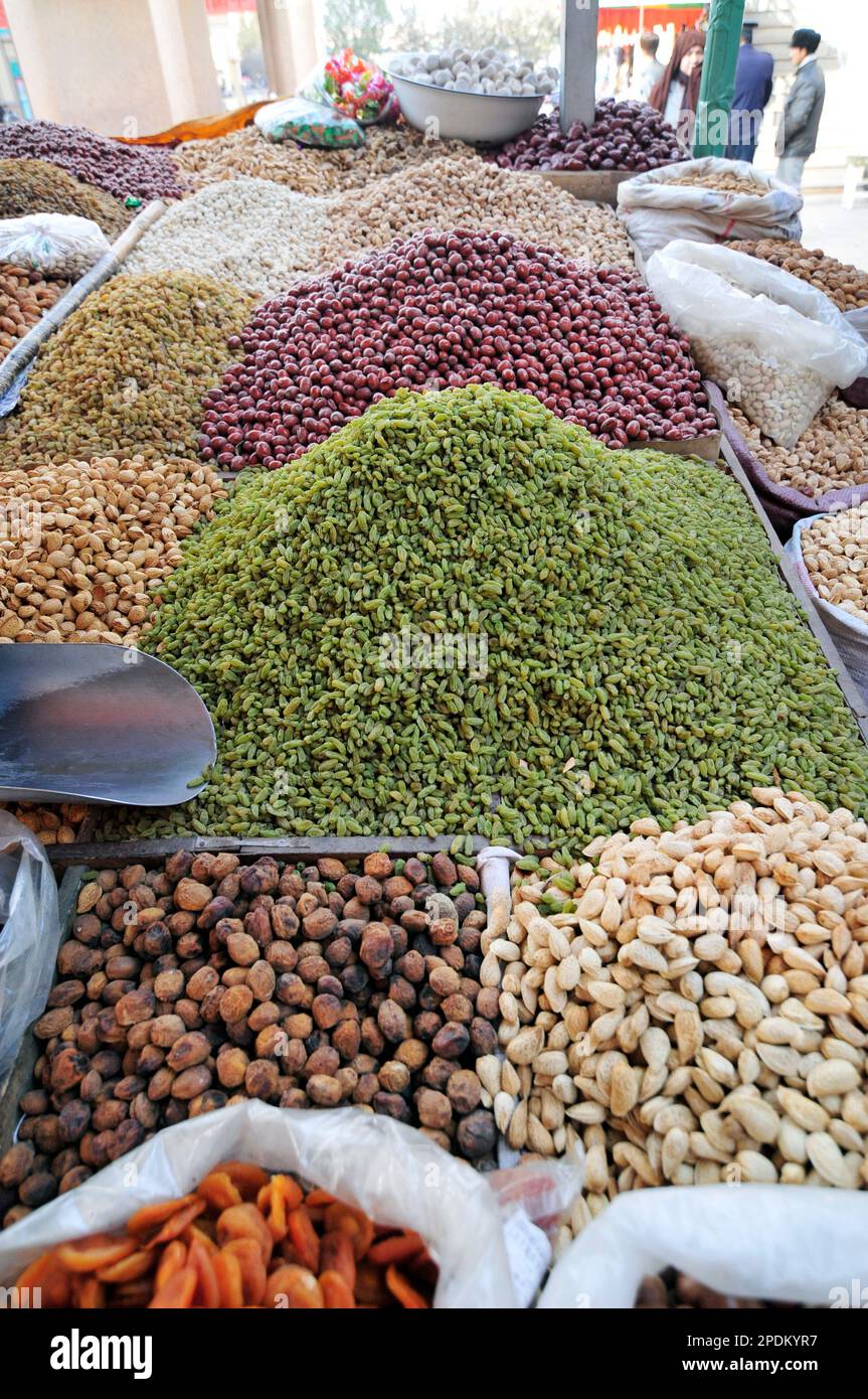 Un venditore di frutta secca e noci nella città vecchia di Kashgar, Xinjiang, Cina. Foto Stock