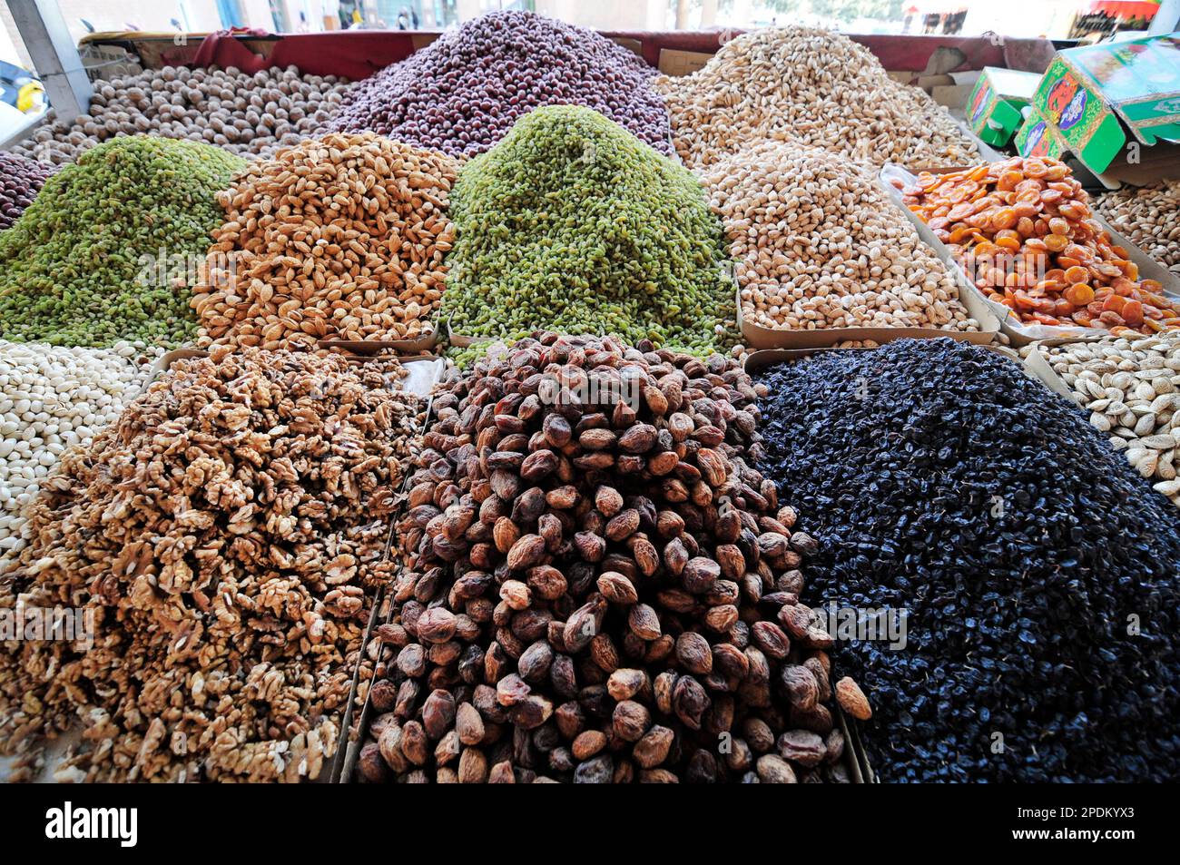 Un venditore di frutta secca e noci nella città vecchia di Kashgar, Xinjiang, Cina. Foto Stock