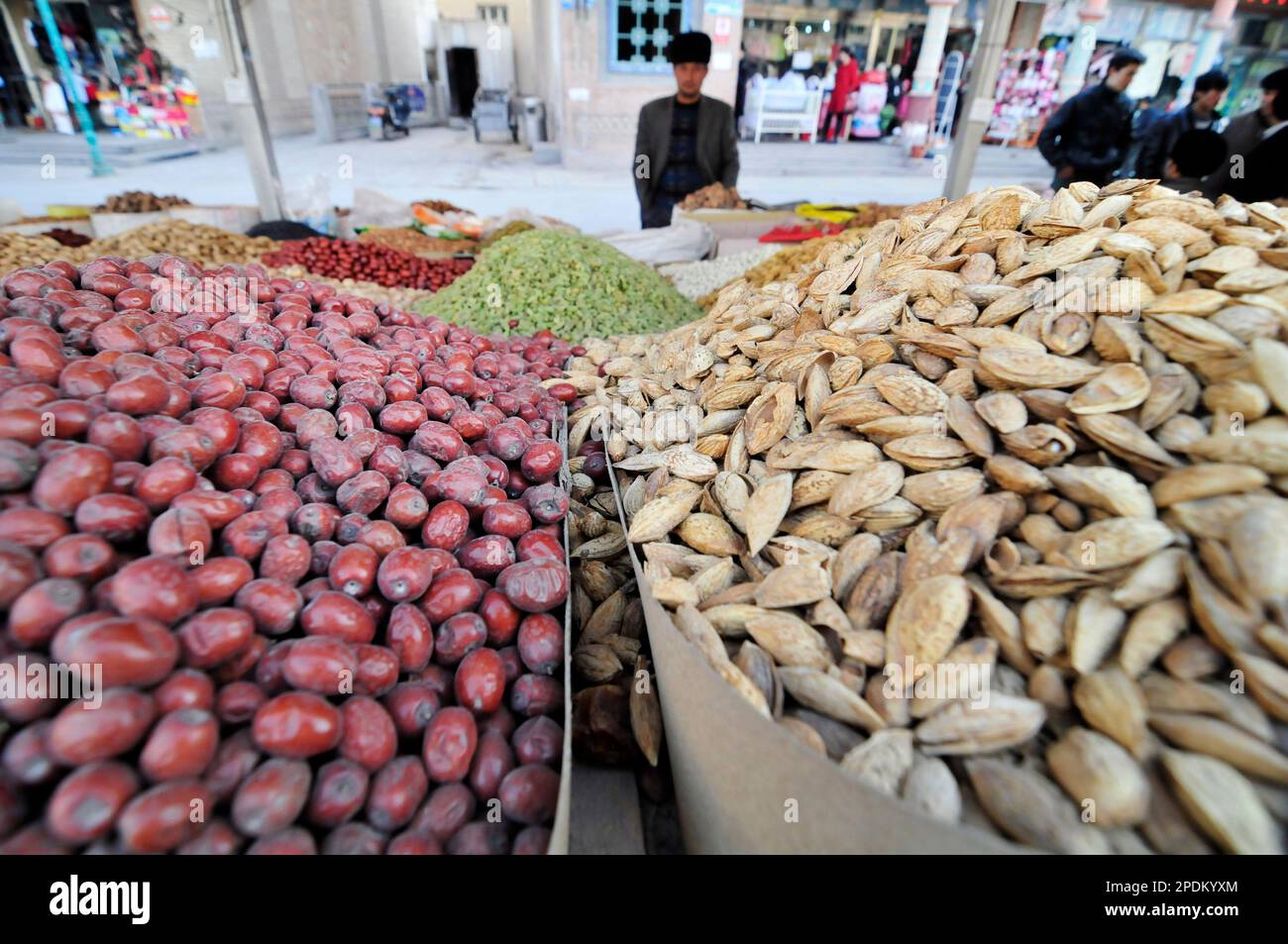 Un venditore di frutta secca e noci nella città vecchia di Kashgar, Xinjiang, Cina. Foto Stock