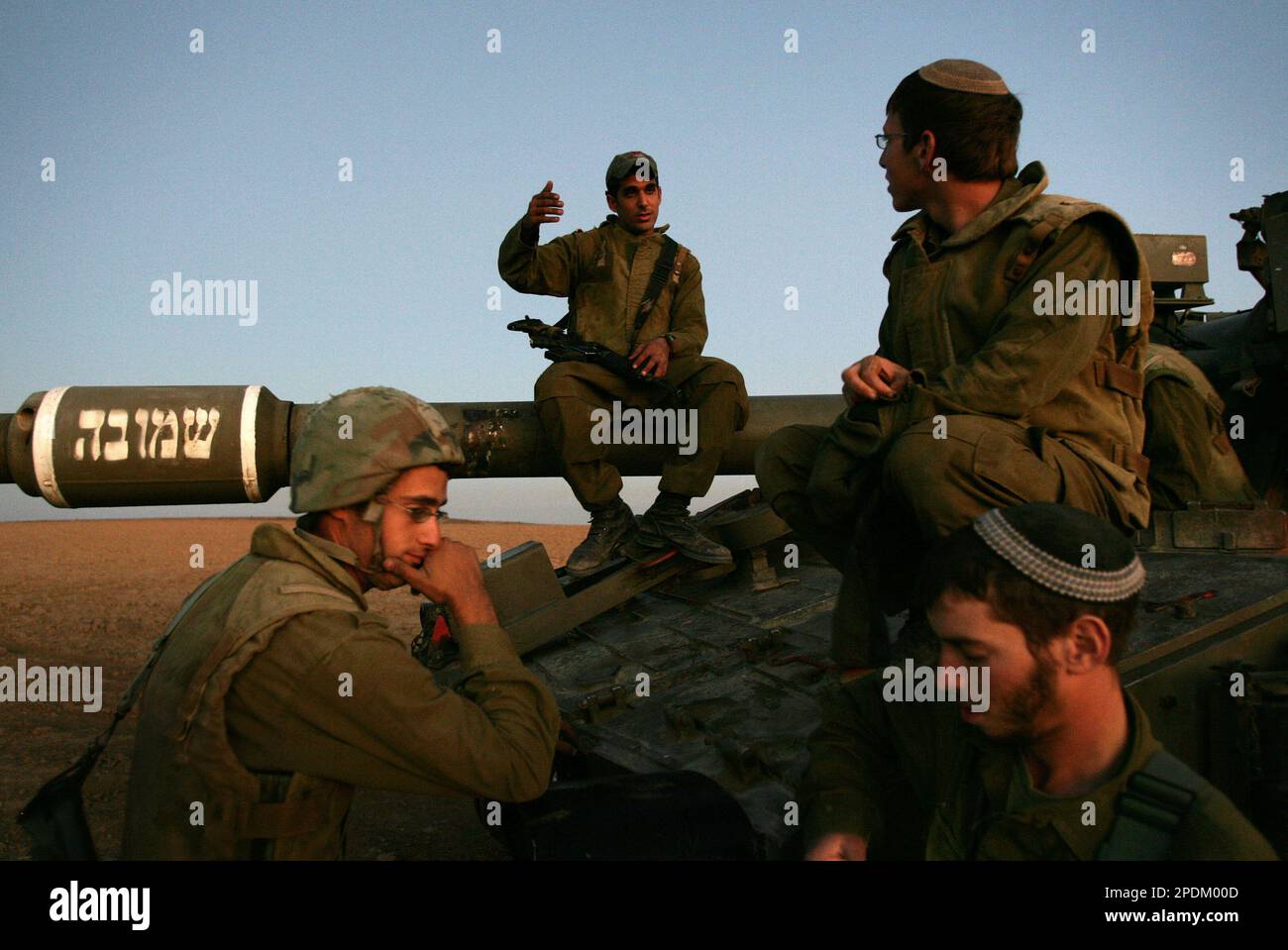 Israeli Soldiers Talk As They Sit On A Tank At The Site Of Mobile ...