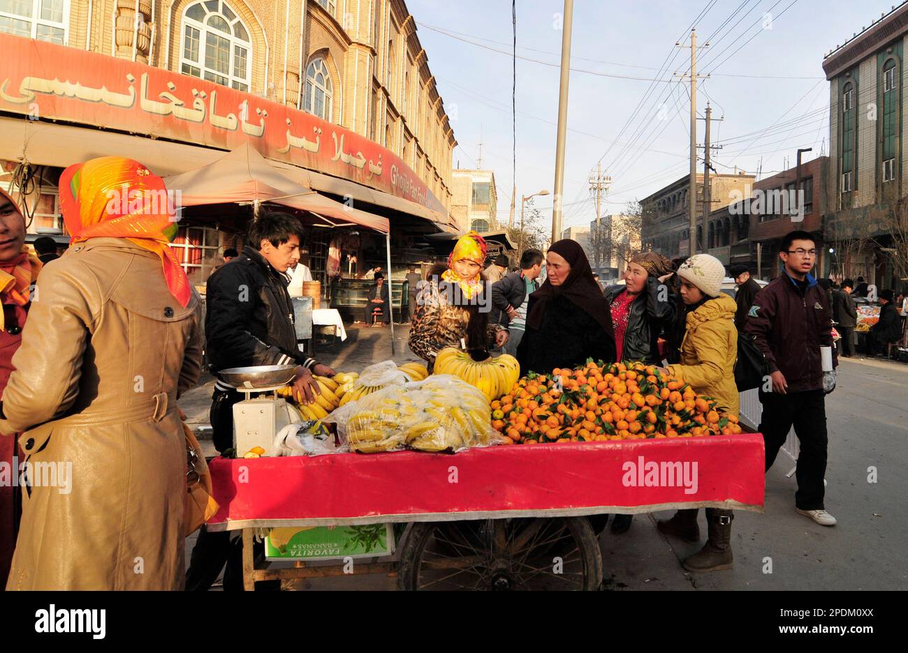 Un fornitore mobile di frutta nella città vecchia di Kashgar, Xinjiang, Cina. Foto Stock