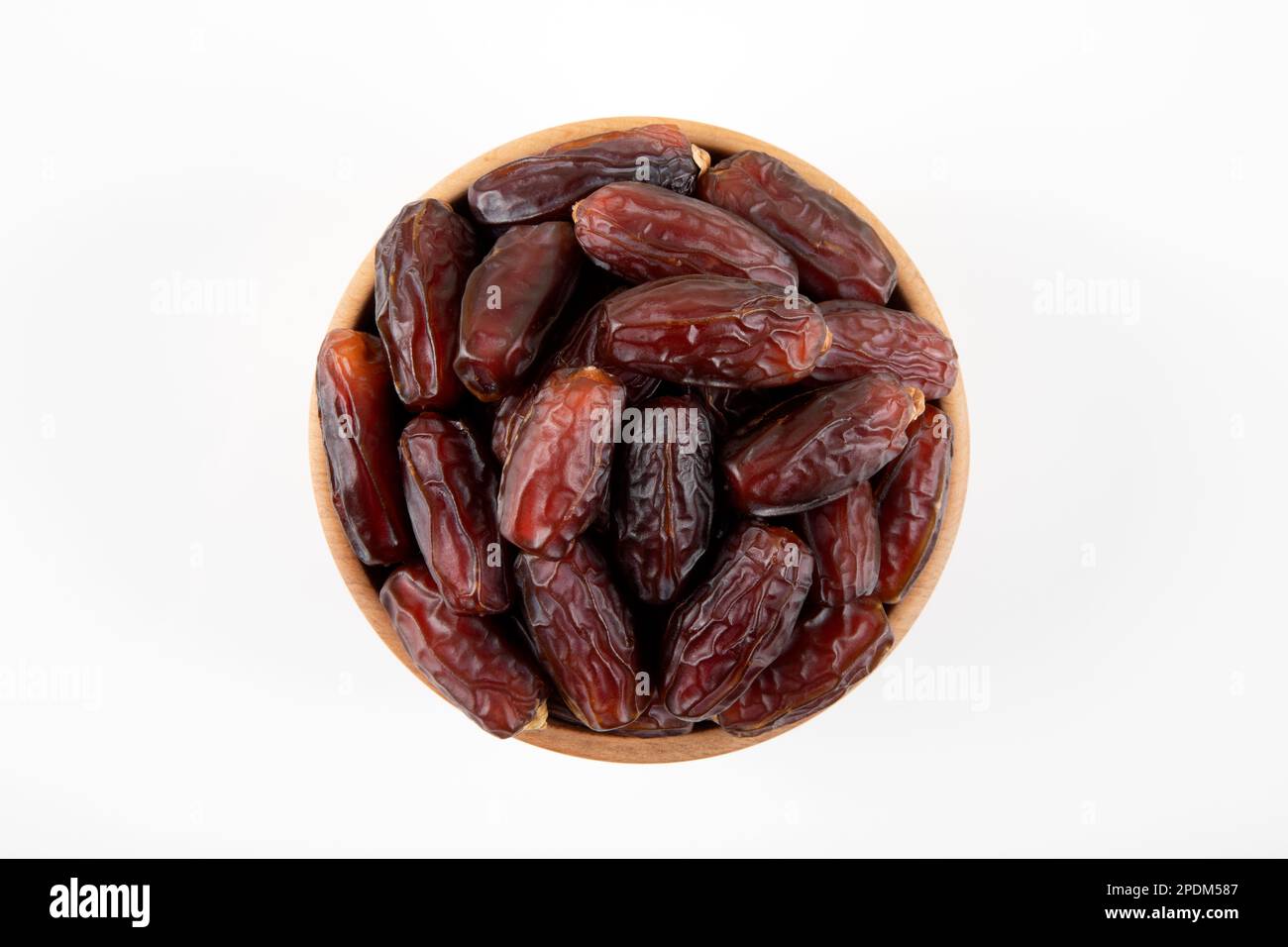 Frutta di data in ciotola di legno, su sfondo bianco, vista dall'alto Foto Stock