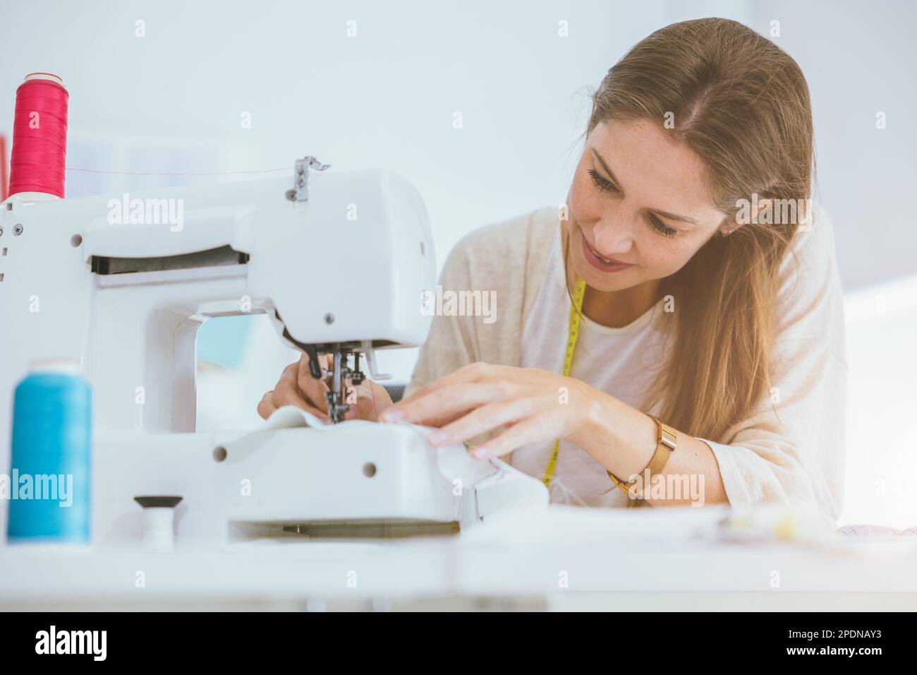 costume professionale donna lavoro godere con la macchina da cucire digitale felice in studio su misura Foto Stock