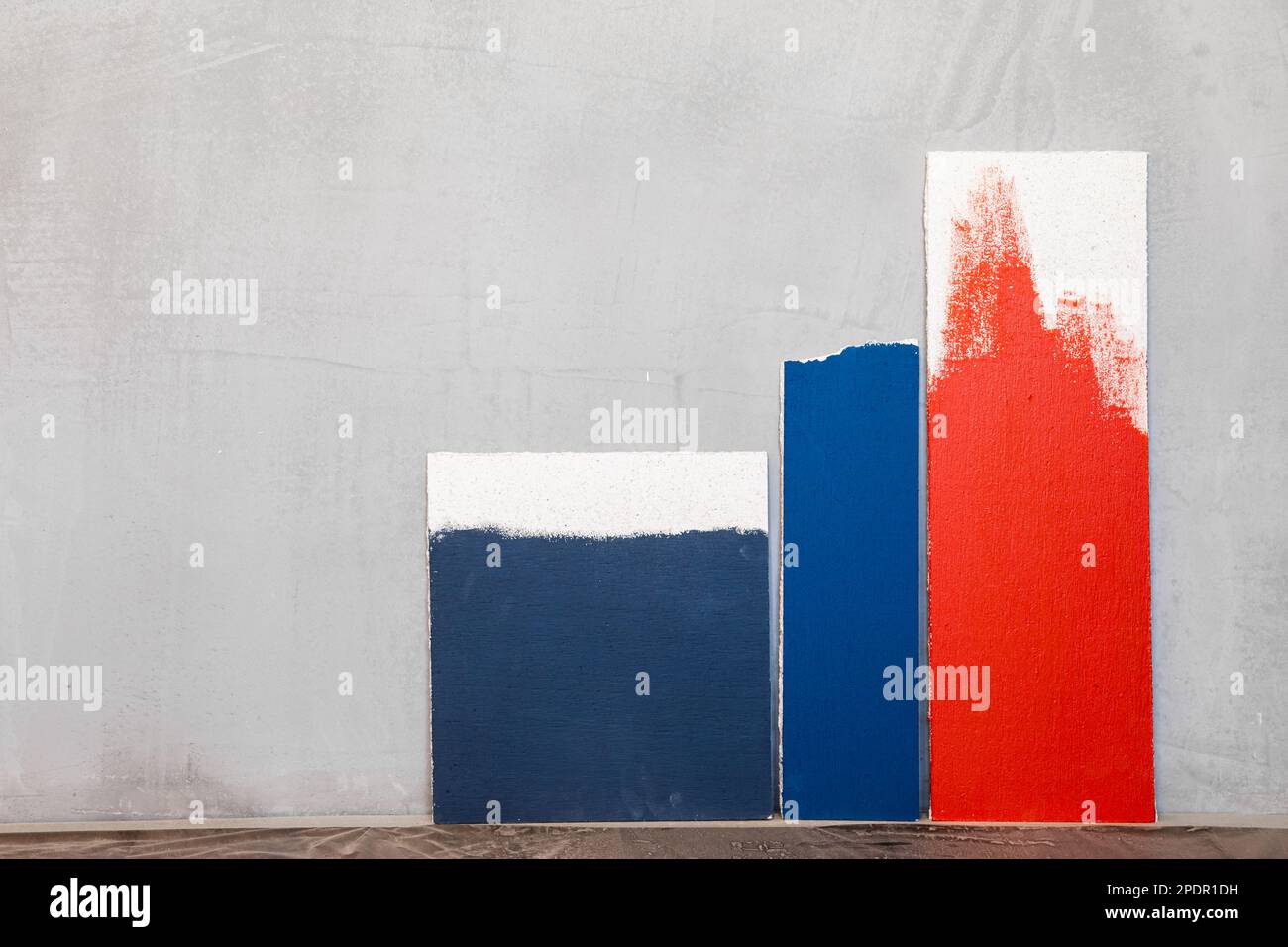 Campionatori di colore rosso e blu a parete in gesso bianco. Scelta del colore della pittura della parete durante il rinnovo della casa Foto Stock