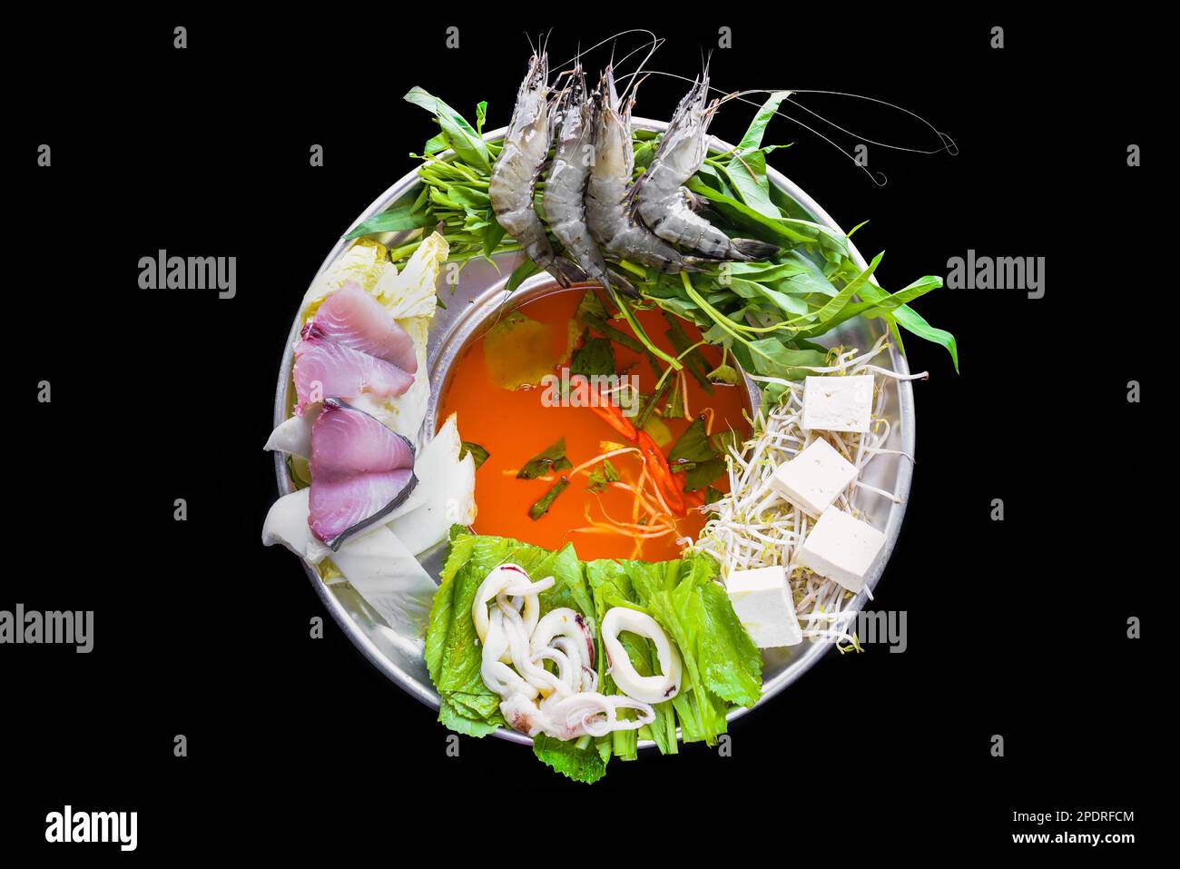 Hot pot coreano con pesce crudo su sfondo nero Foto Stock