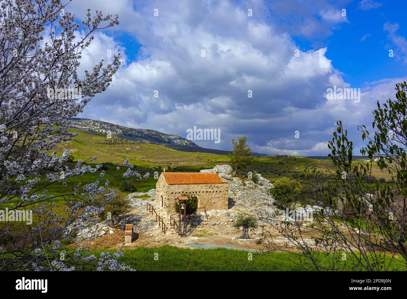 Piccola cappella in roccia con tetto in piastrelle rosse e campana, nell'entroterra dalla zona di Phaphos Pafos di Cipro in inverno, sole invernale Foto Stock