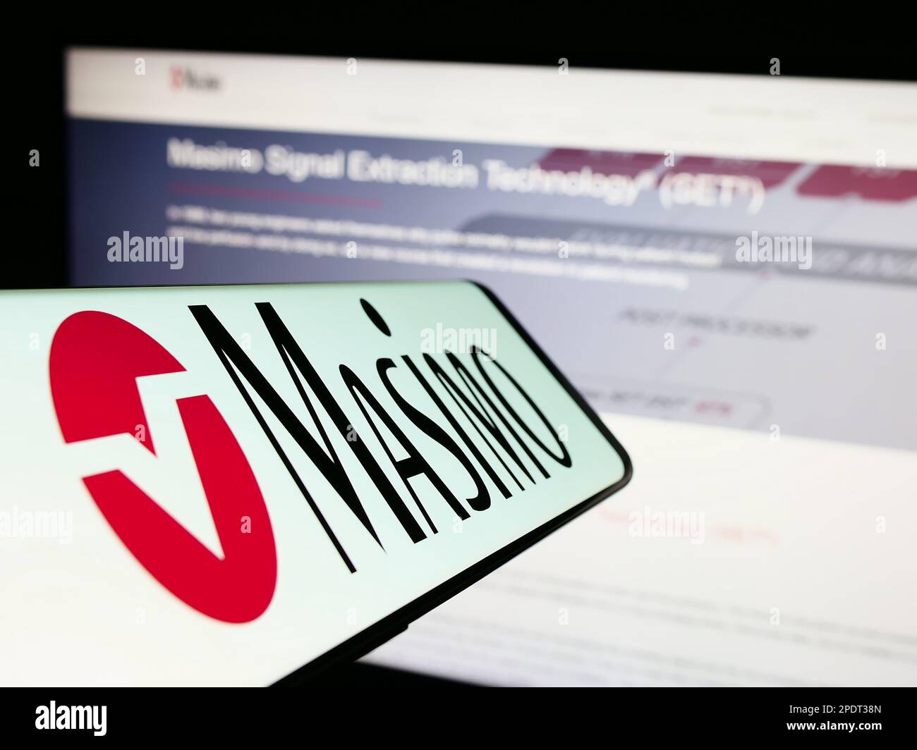 Smartphone con il logo della società di tecnologia medica Masimo Corporation sullo schermo di fronte al sito Web. Messa a fuoco al centro a sinistra del display del telefono. Foto Stock