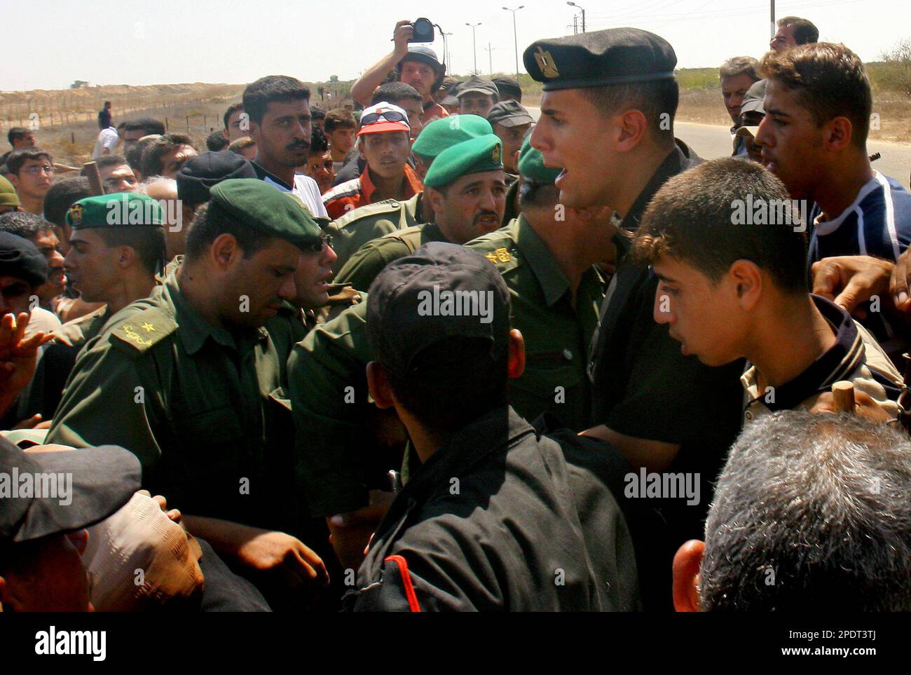 An Egyptian border guard and Palestinian police together try to prevent