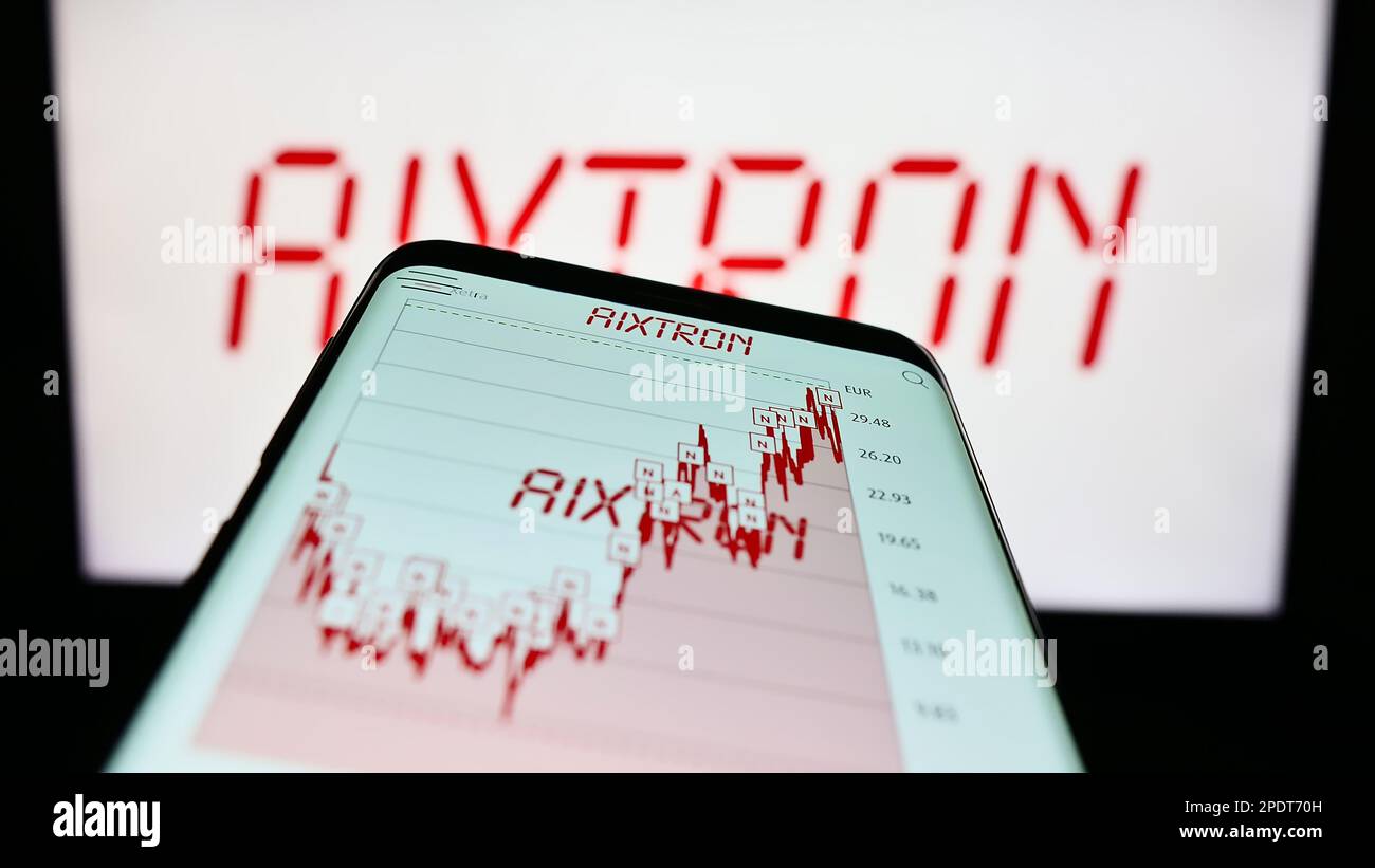 Telefono cellulare con sito web della società tedesca di tecnologia Aixtron se sullo schermo di fronte al logo aziendale. Messa a fuoco in alto a sinistra del display del telefono. Foto Stock