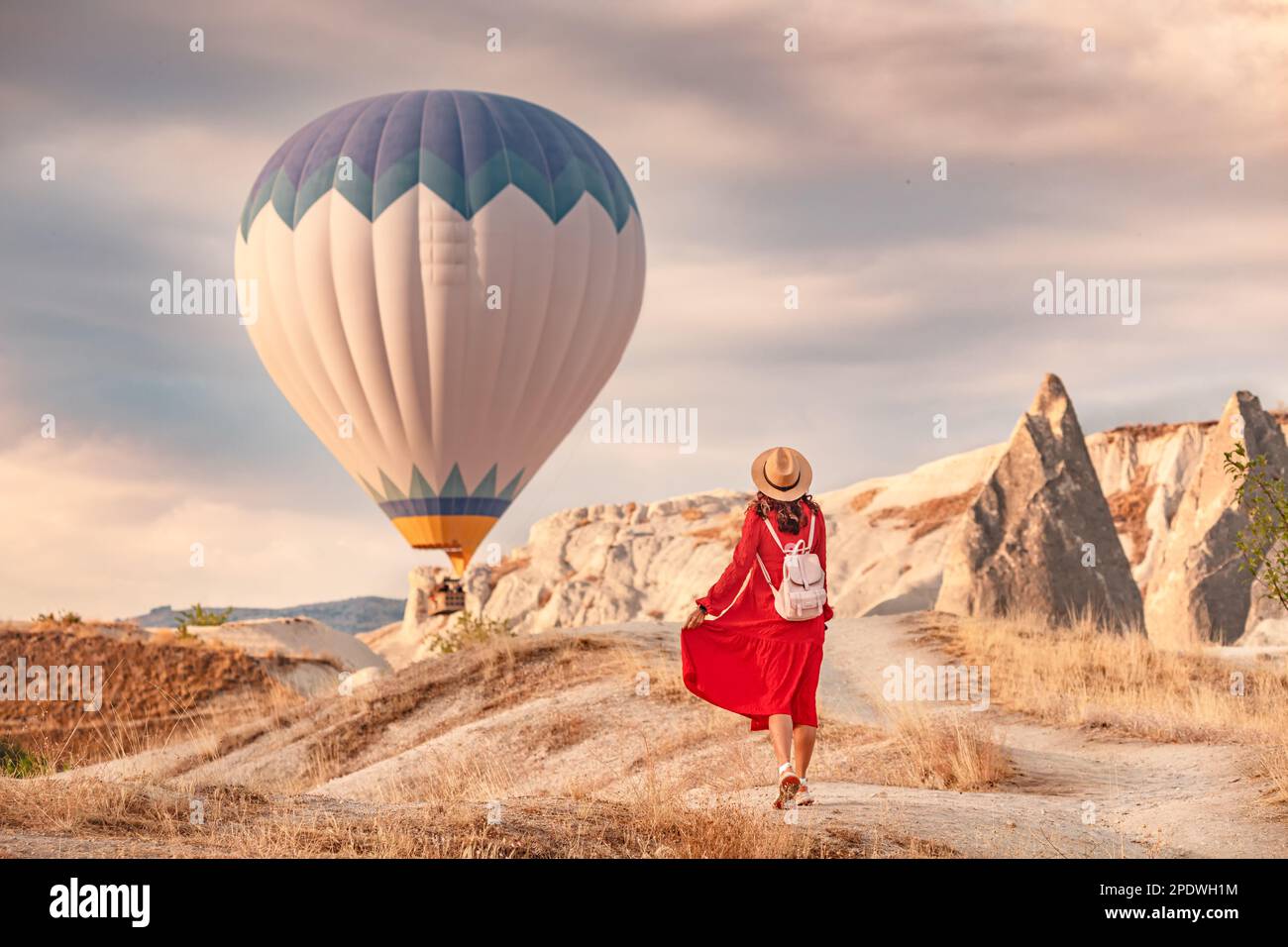 L'aria era viva con la vista dei palloncini che si accalcavano nel cielo sopra, e la ragazza sotto di loro nel suo abito rosso che splende alla luce del sole. Lei stoo Foto Stock