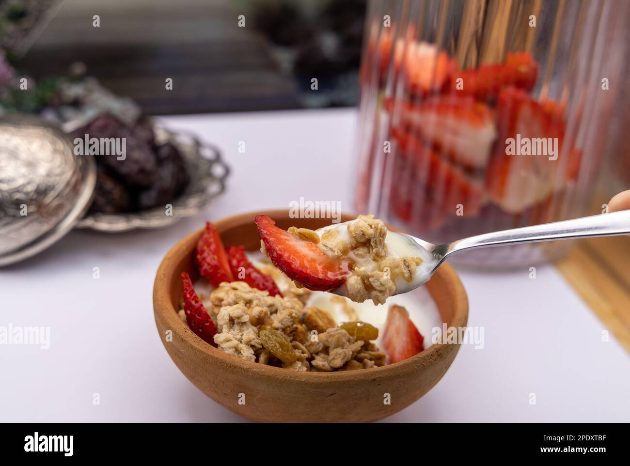 Colazione sana - cereali avena, fragola, miele con yogurt noci nel recipiente di argilla Foto Stock