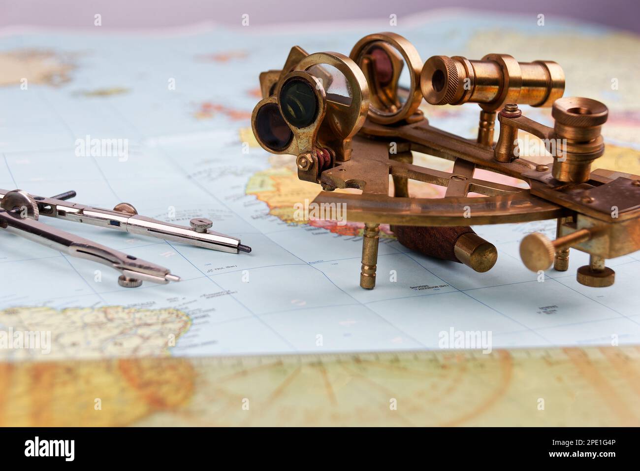 sestante nautico con ottica, bussola e righello giacente su carta mappa del mondo Foto Stock