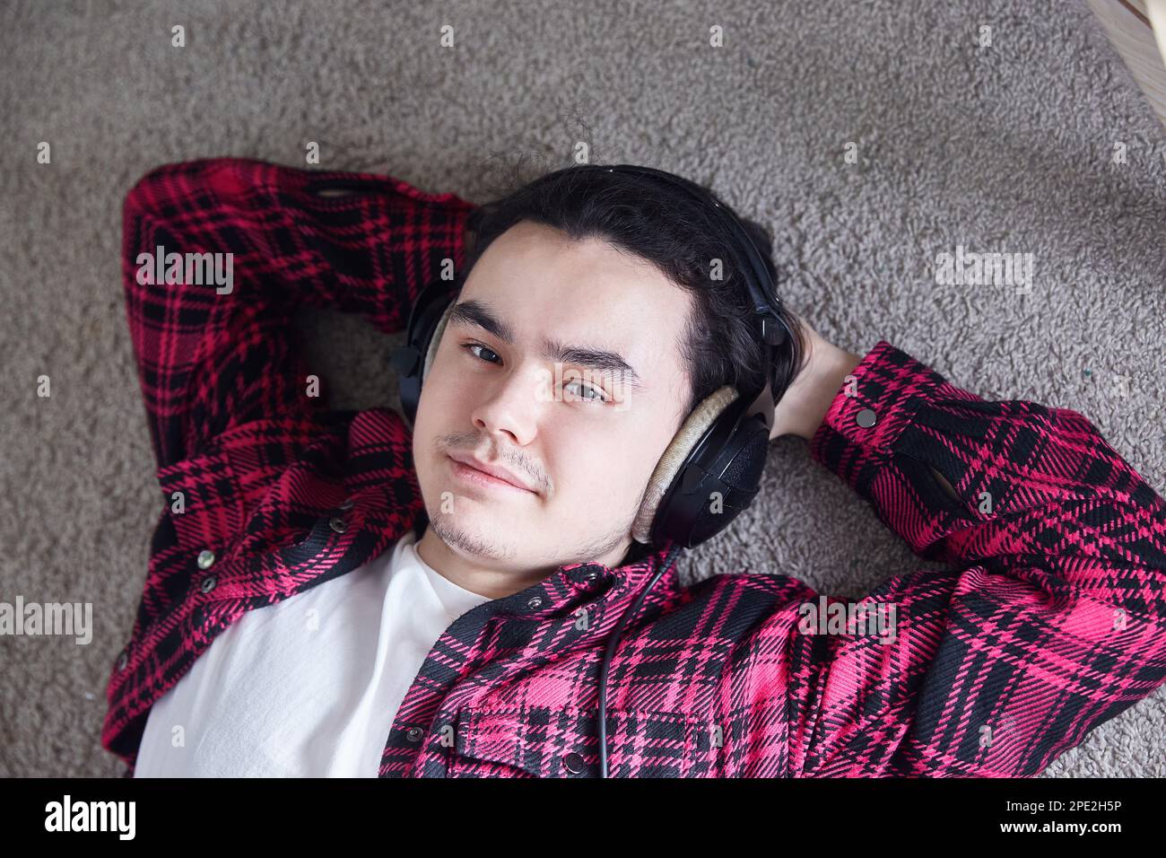 Ritratto di giovane uomo con cuffie, sorridente felicemente Foto Stock