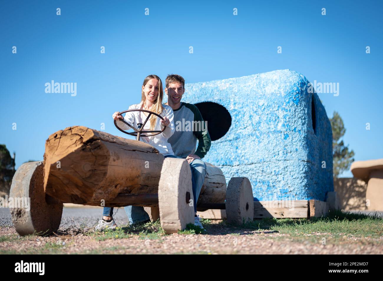 Giovane coppia a cavallo di un'automobile fatta di legno Foto Stock