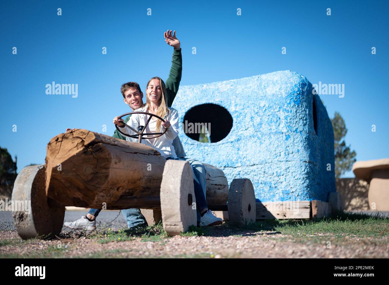 Giovane coppia a cavallo di un'automobile fatta di legno Foto Stock