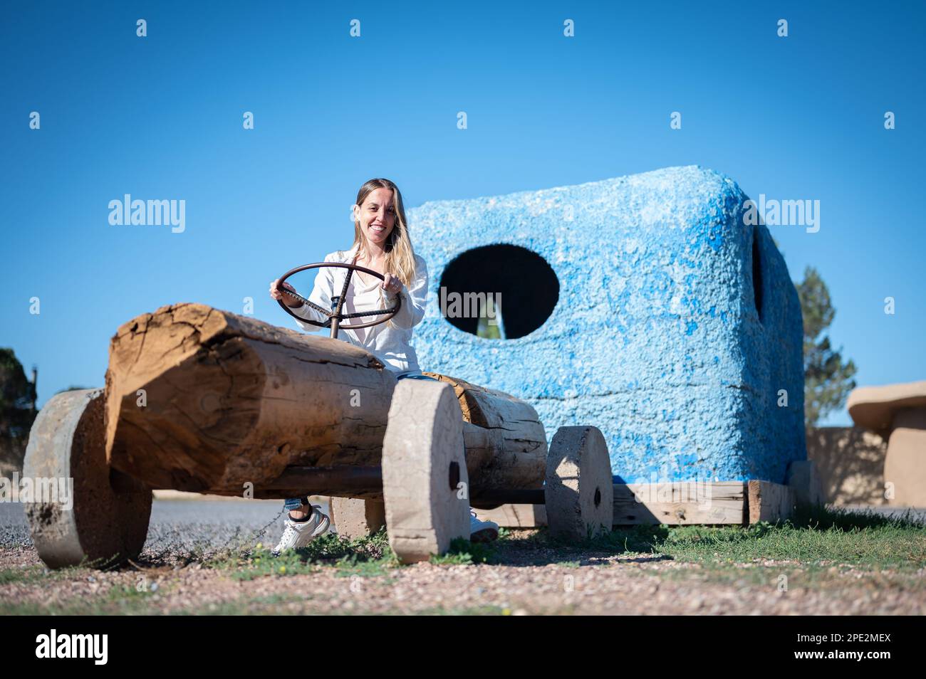 Ragazza giovane in sella ad un'automobile fatta di legno Foto Stock