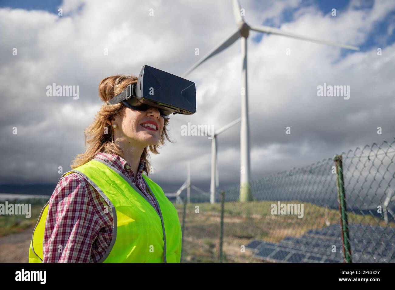 Un ingegnere indossa occhiali per la realtà aumentata in una fattoria solare, concetto di energia sostenibile. Foto Stock Un ingegnere indossa occhiali per la realtà aumentata in una fattoria solare, concetto di energia sostenibile. Foto Stock