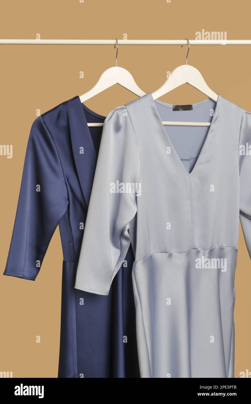 Abiti da donna. Appendiabiti con eleganti ed eleganti abiti in seta blu in atelier di moda. Pezzi di moda senza tempo di buona qualità. Foto Stock