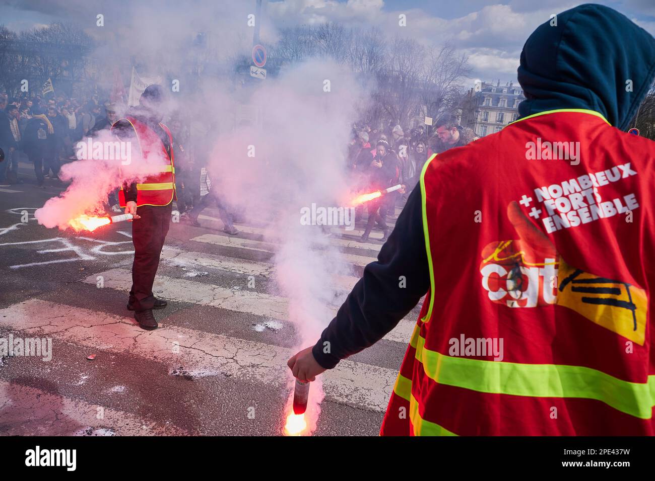 Parigi, FRANCIA. 15th Mar, 2023. I membri del sindacato comunista, il CGT, usano il fardello mentre dieci di migliaia di persone marciano nel centro di Parigi contro i piani di riforma delle pensioni. I piani del governo di Emmanuel Macron, per aumentare l'età pensionabile da 62 a 64 anni, sono stati accolti con rabbia e proteste. Credit: ZUMA Press, Inc./Alamy Live News Foto Stock