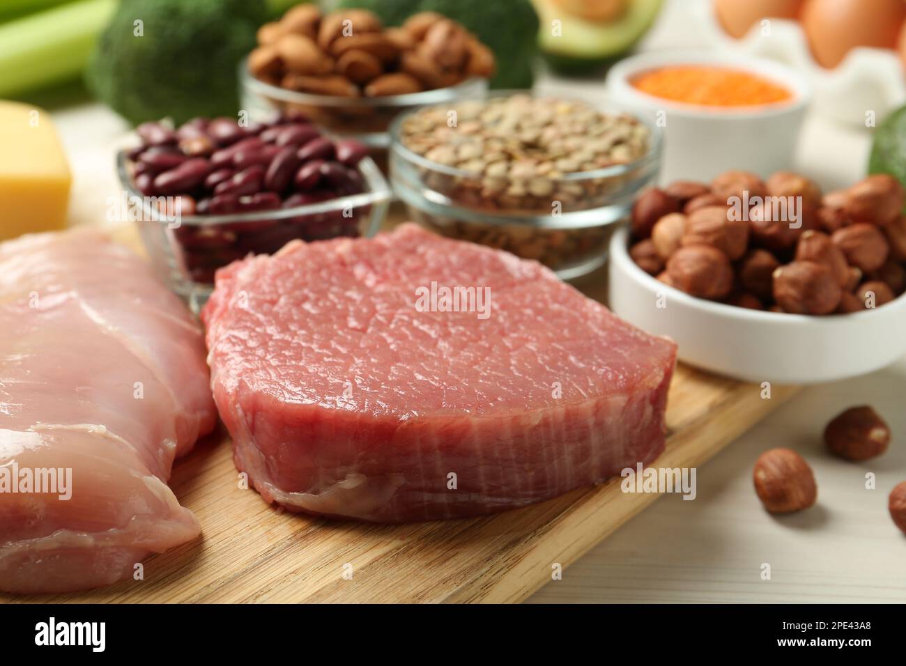 Carni fresche ed altri prodotti su tavola di legno bianco, primo piano. Fonti di amminoacidi essenziali Foto Stock