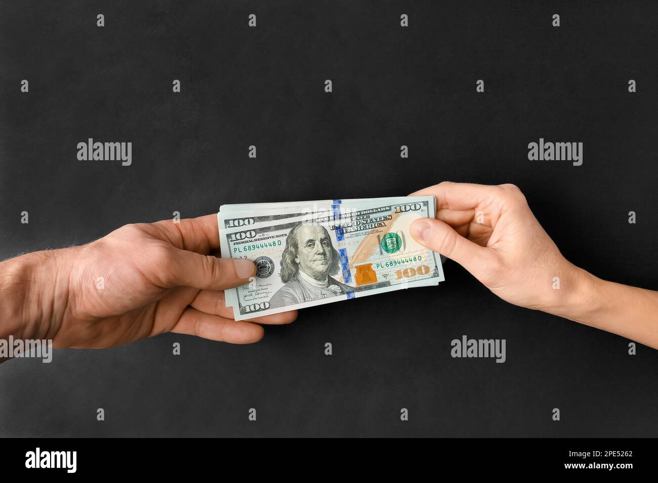 I dollari sono passati di mano in mano su uno sfondo nero con spazio per il testo. Il concetto di corruzione, corruzione, prestito. Foto Stock