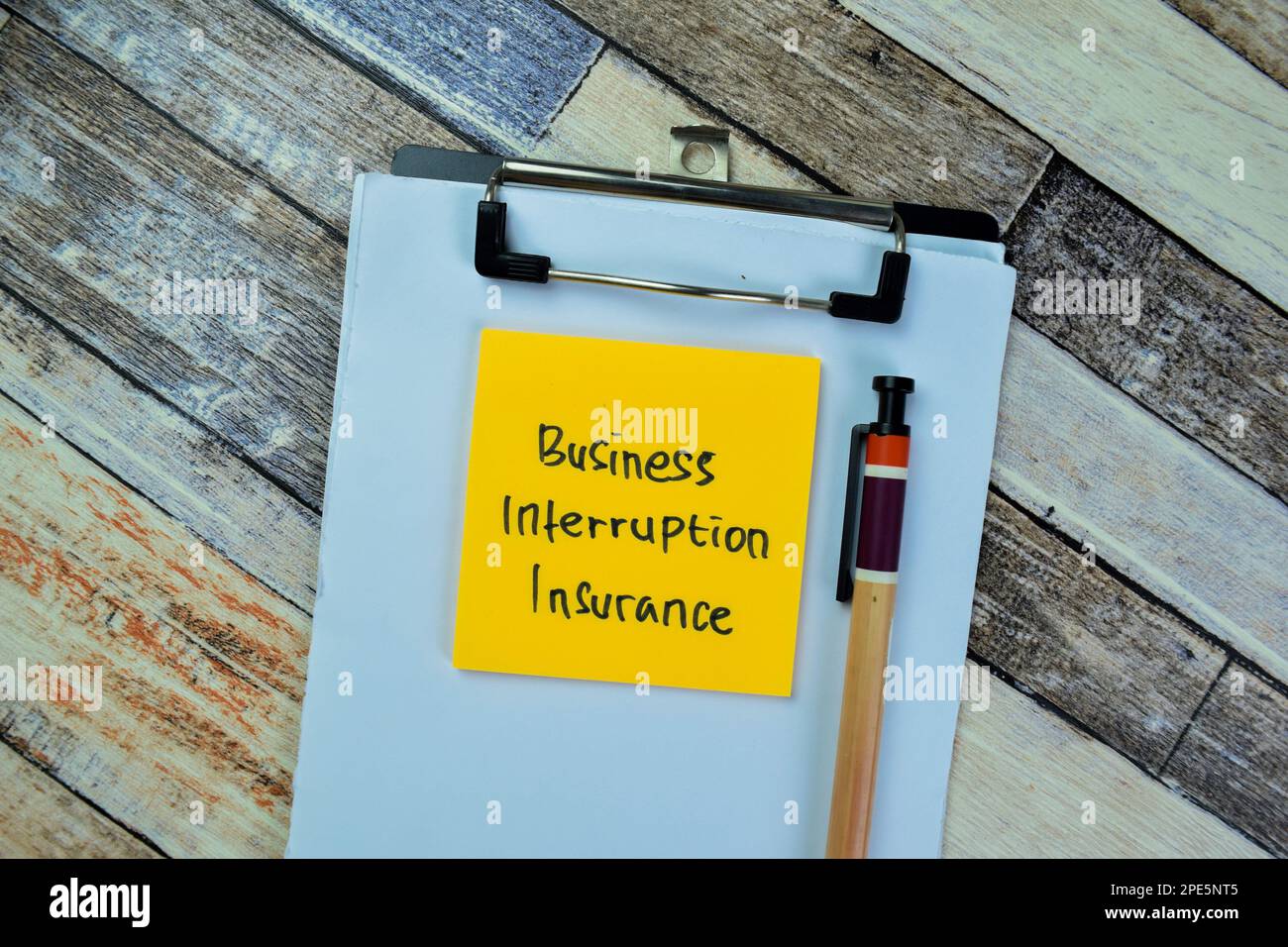 Concetto di Business Interruption Insurance scrivere su foglietti adesivi isolati su tavola di legno. Foto Stock
