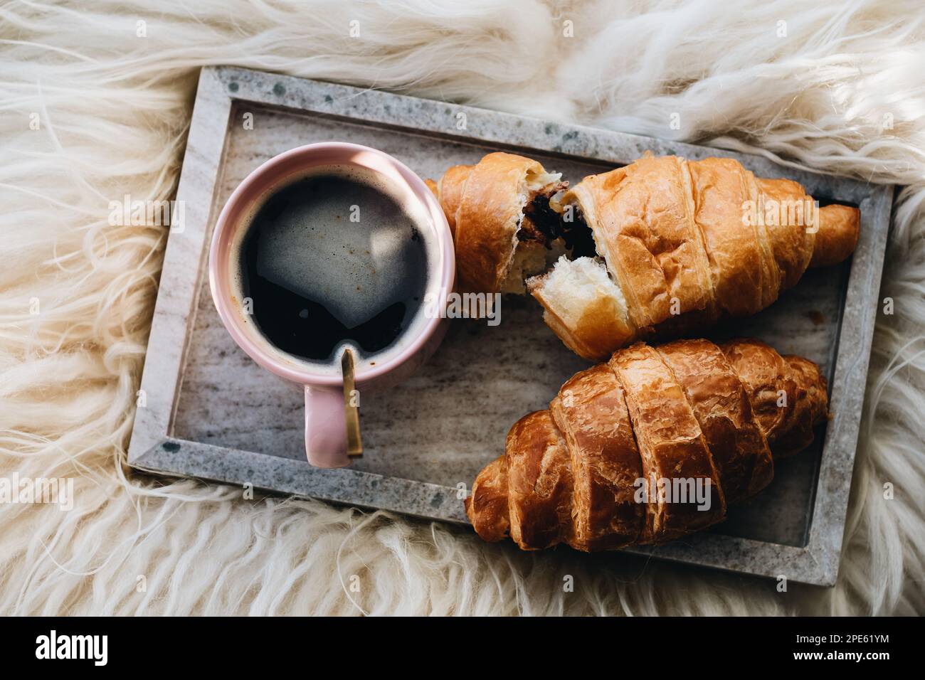 Tazza di caffè con croissant al cioccolato sul vassoio Foto Stock