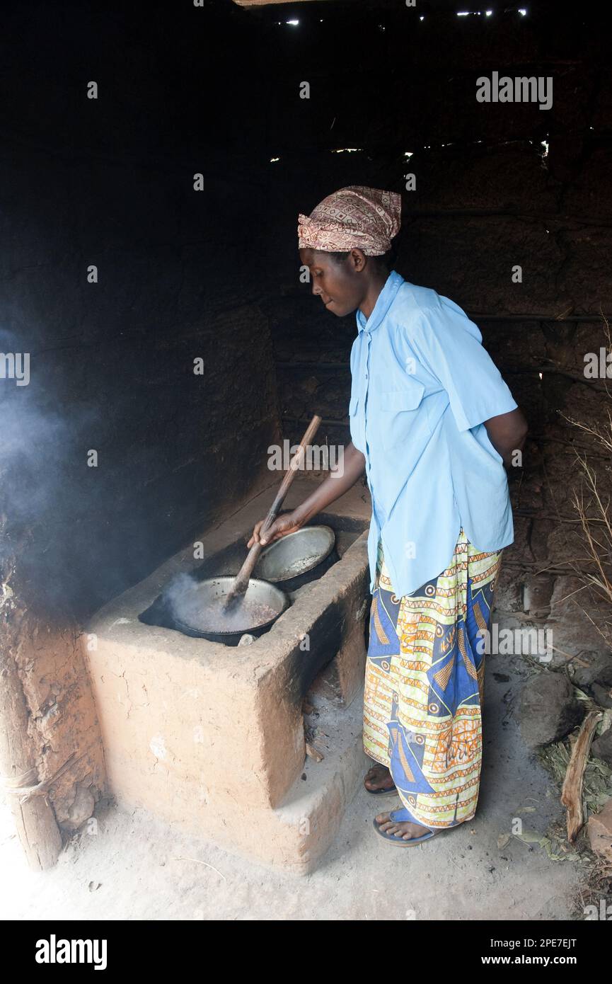 Donna che prepara il cibo al fornello in una capanna, Ruanda Foto Stock