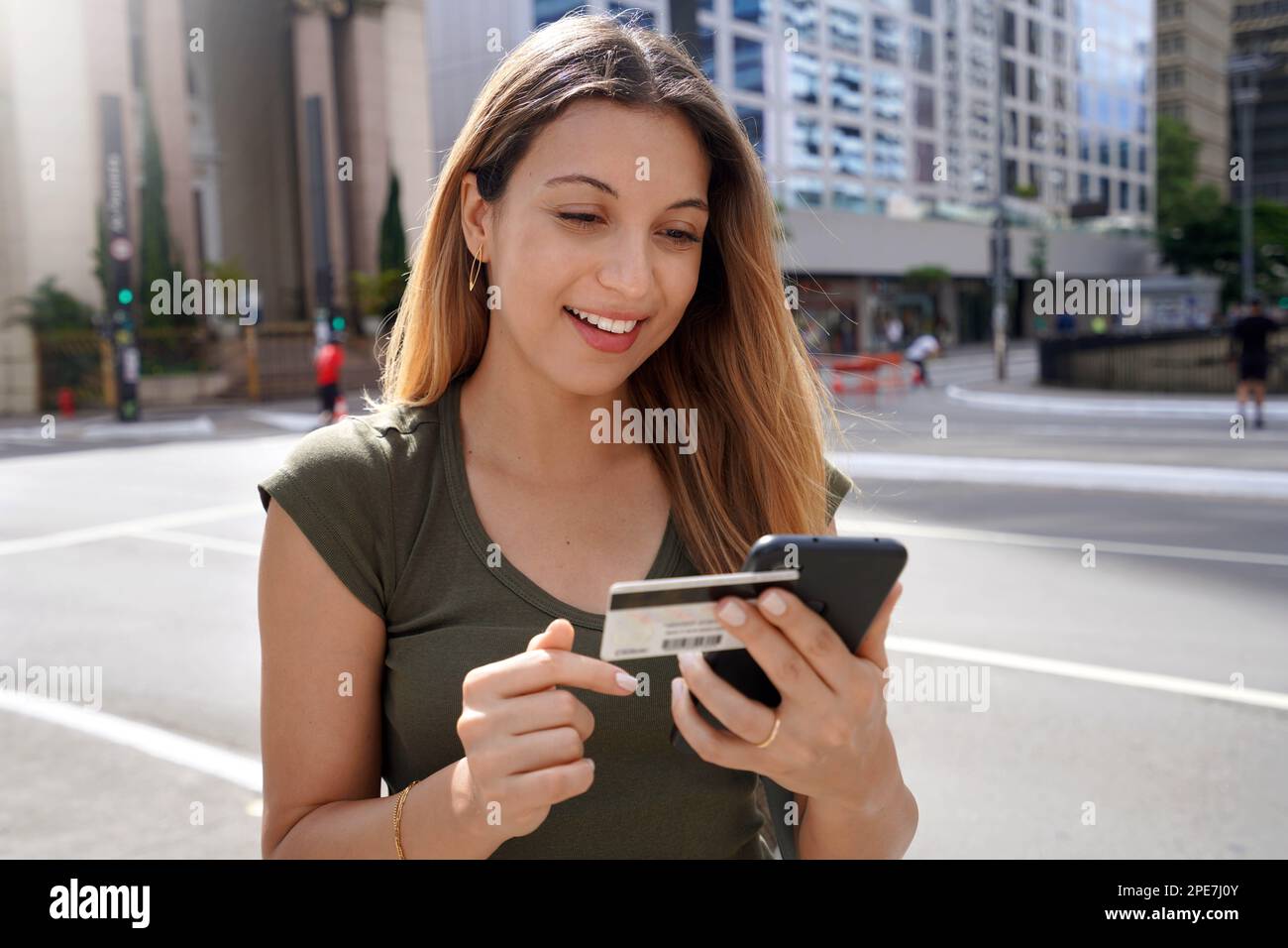 Ragazza di moda utilizzando carta di credito e smartphone per lo shopping online all'aperto Foto Stock