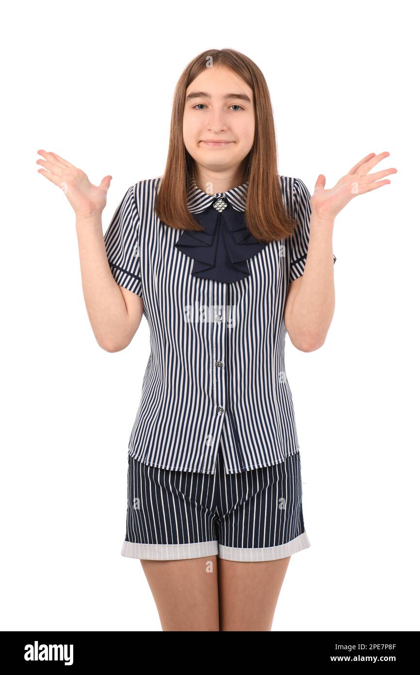 Giovane bella ragazza in uniforme scolastica su sfondo bianco, espressione senza canti e confusa con braccia e mani sollevate. Concetto di dubbio. Foto Stock