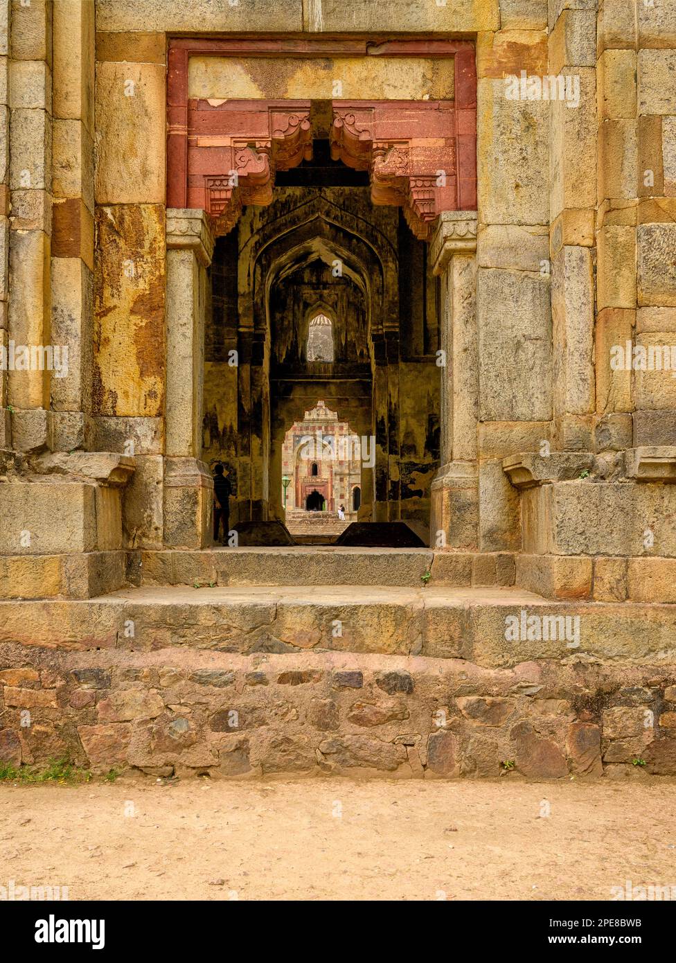 La moschea di Bara Gumbad si vede attraverso l'entrata del mausoleo di Shish Gumbad Foto Stock