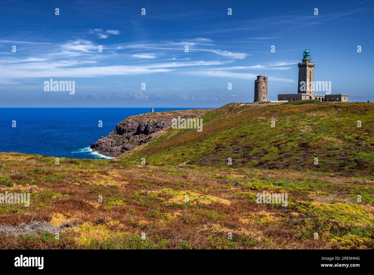 Scogliere sulla costa atlantica con l'antico faro a Cap Frehel in Bretagna, Francia; Phare du Cap Frehel Foto Stock