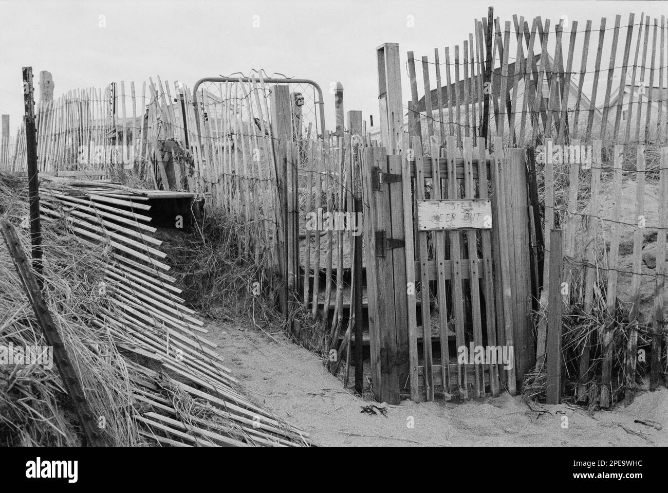 Una tempesta recinzione e cancello di legno con un cartello Reading Privat tenere fuori sotto una fila di case estive a Salisbury Beach, Massachusetts. L'immagine è stata acquisita Foto Stock