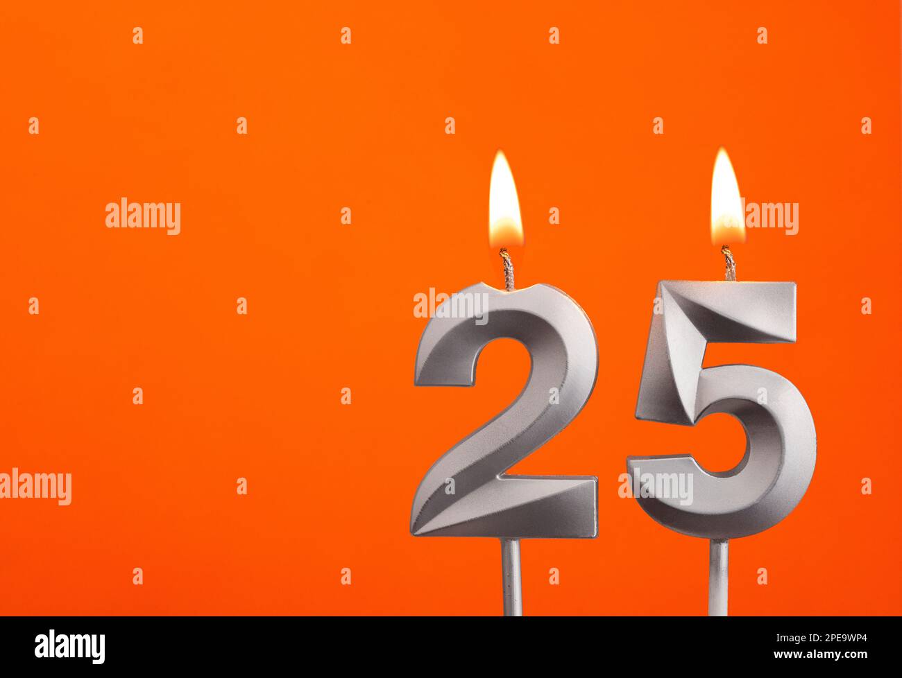 Numero 25 - candela d'anniversario d'argento su sfondo arancione Foto Stock