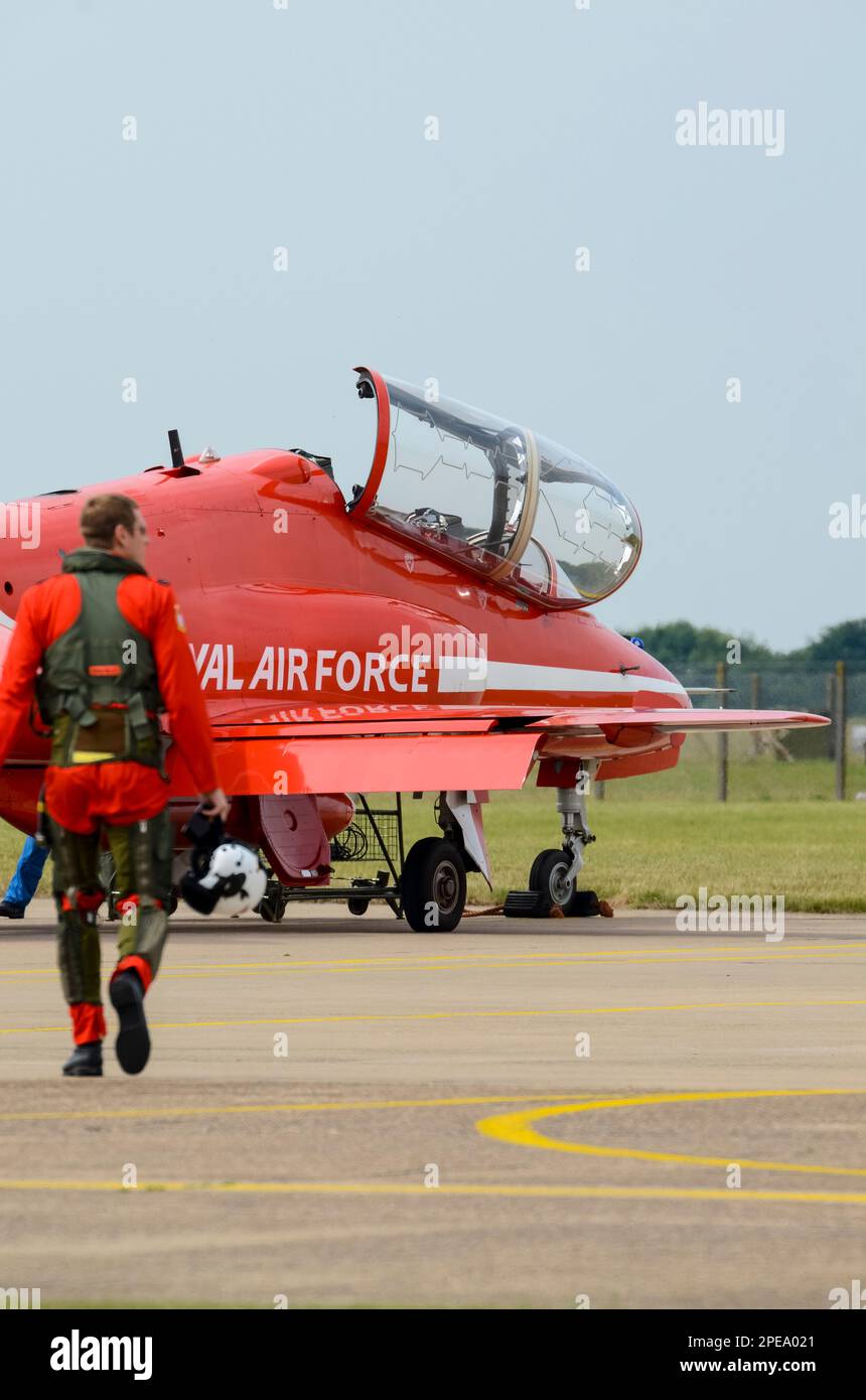 Royal Air Force Red Arrows mostra il pilota della squadra che cammina verso un jet plane BAe Hawk T1 prima di essere esposto al RAF Scampton. Pilota sfocato Foto Stock